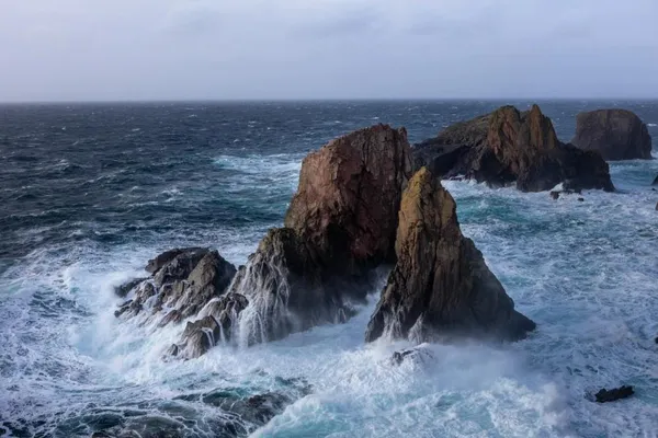 Waves crashing over sea stacks